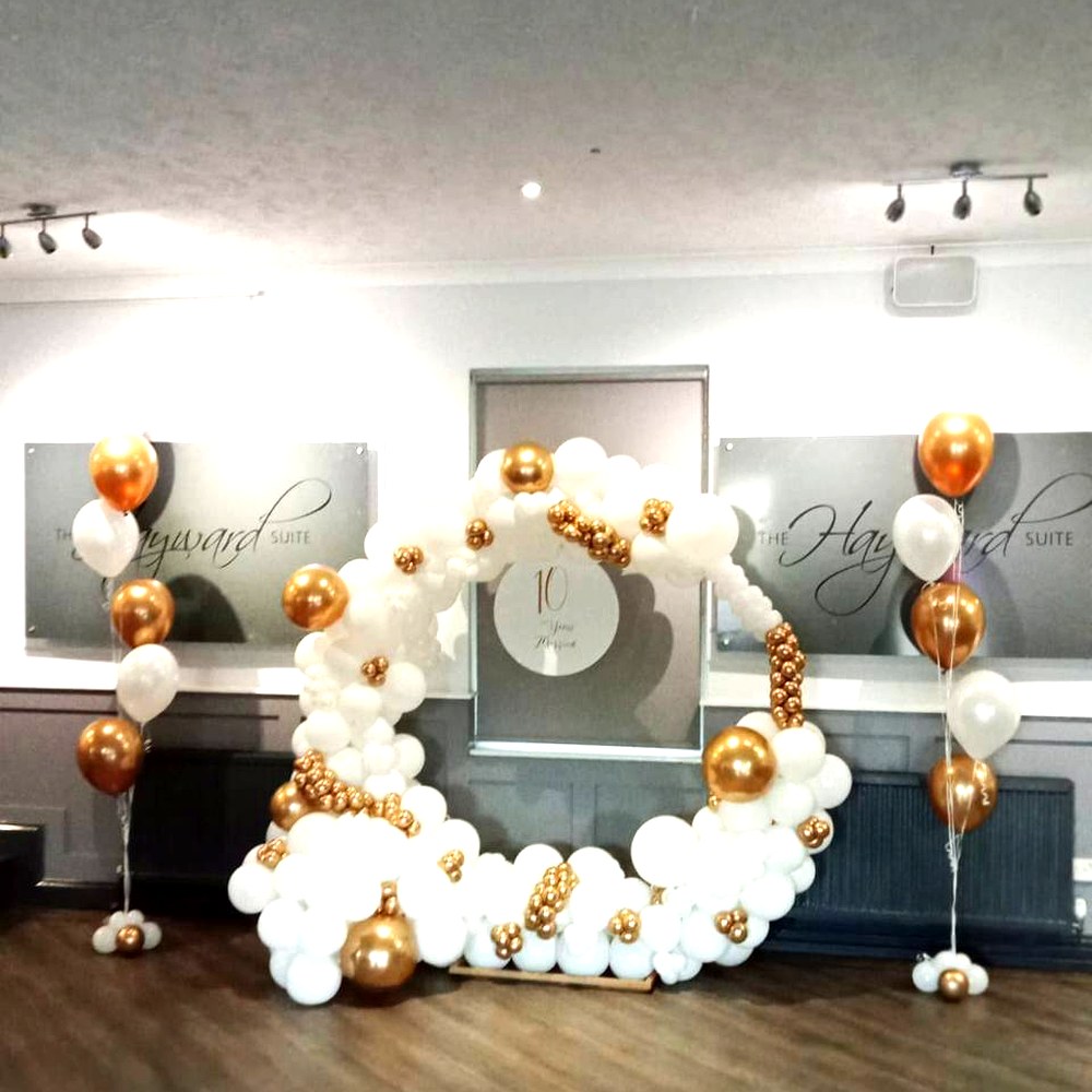 White and gold balloon hoop backdrop with matching balloon columns